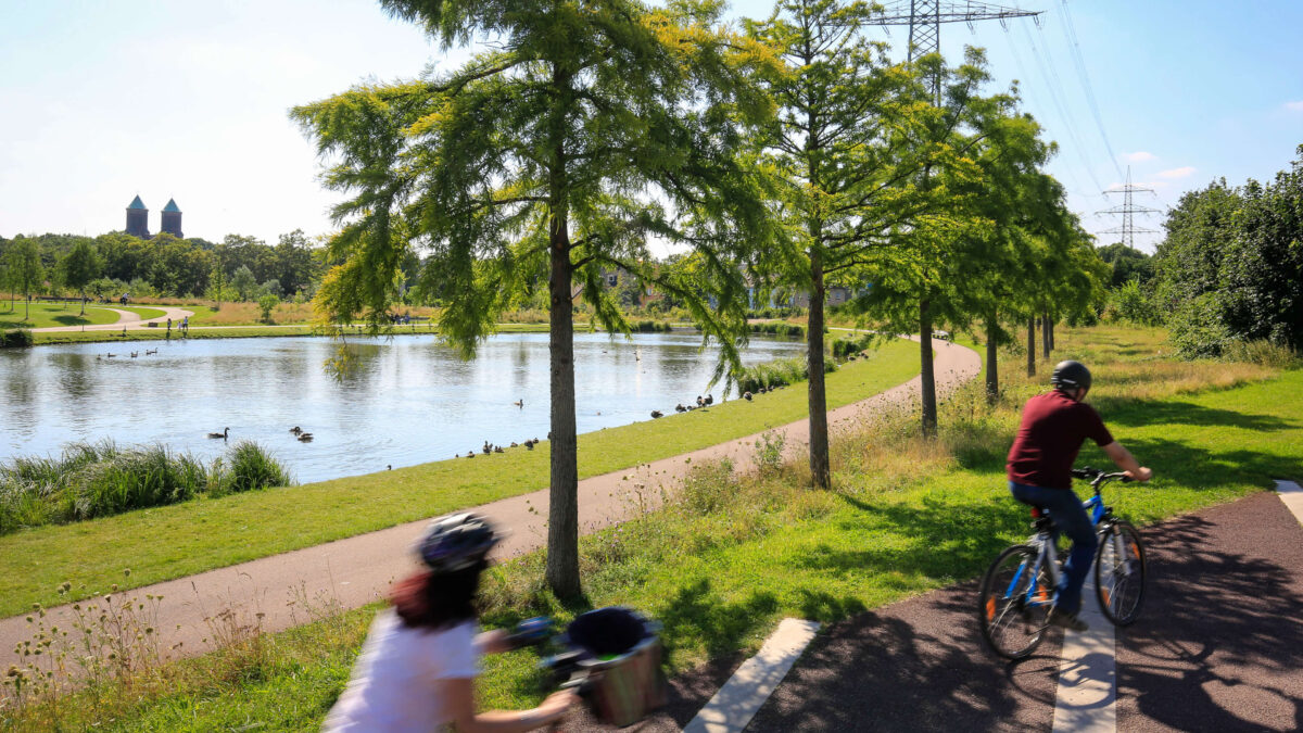 People biking along the Krupp Park pond in Essen, in a photo by Oberhaeuser