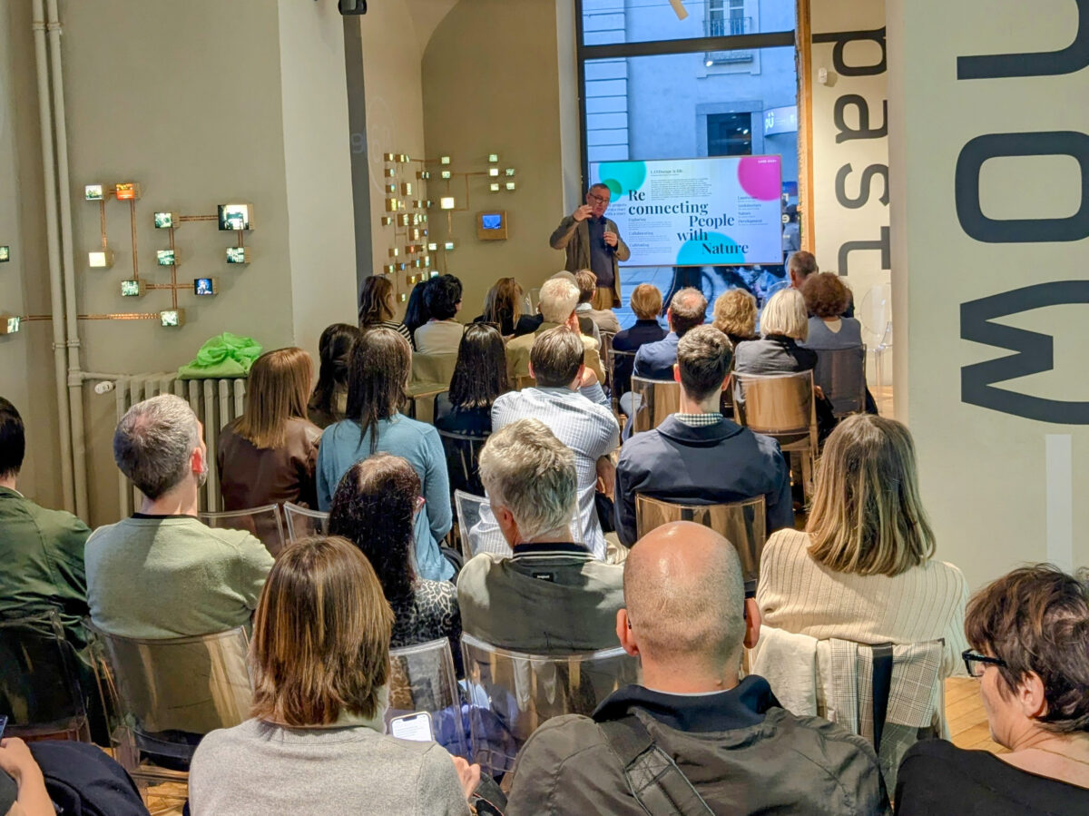 People sitting in a room with a man presenting slides