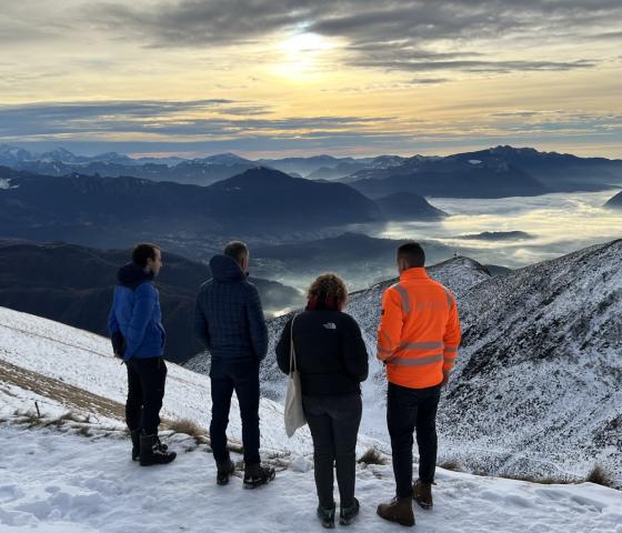 four persons standing on top of a mountain