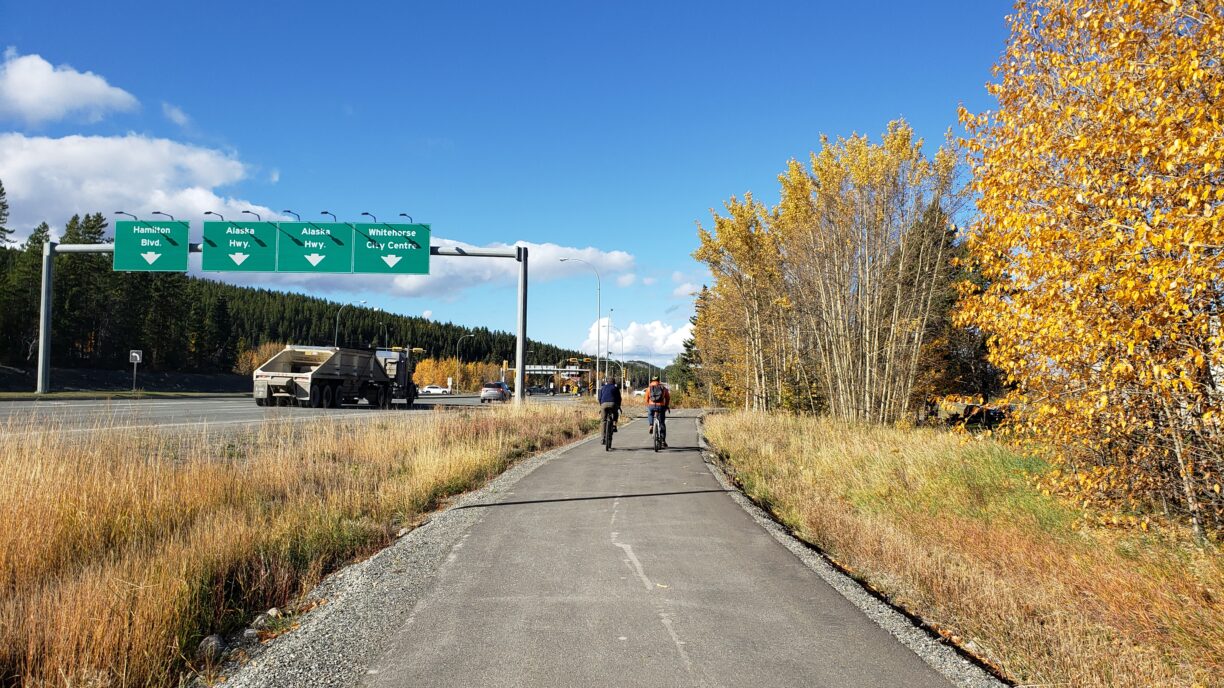 two people riding bikes along a highway
