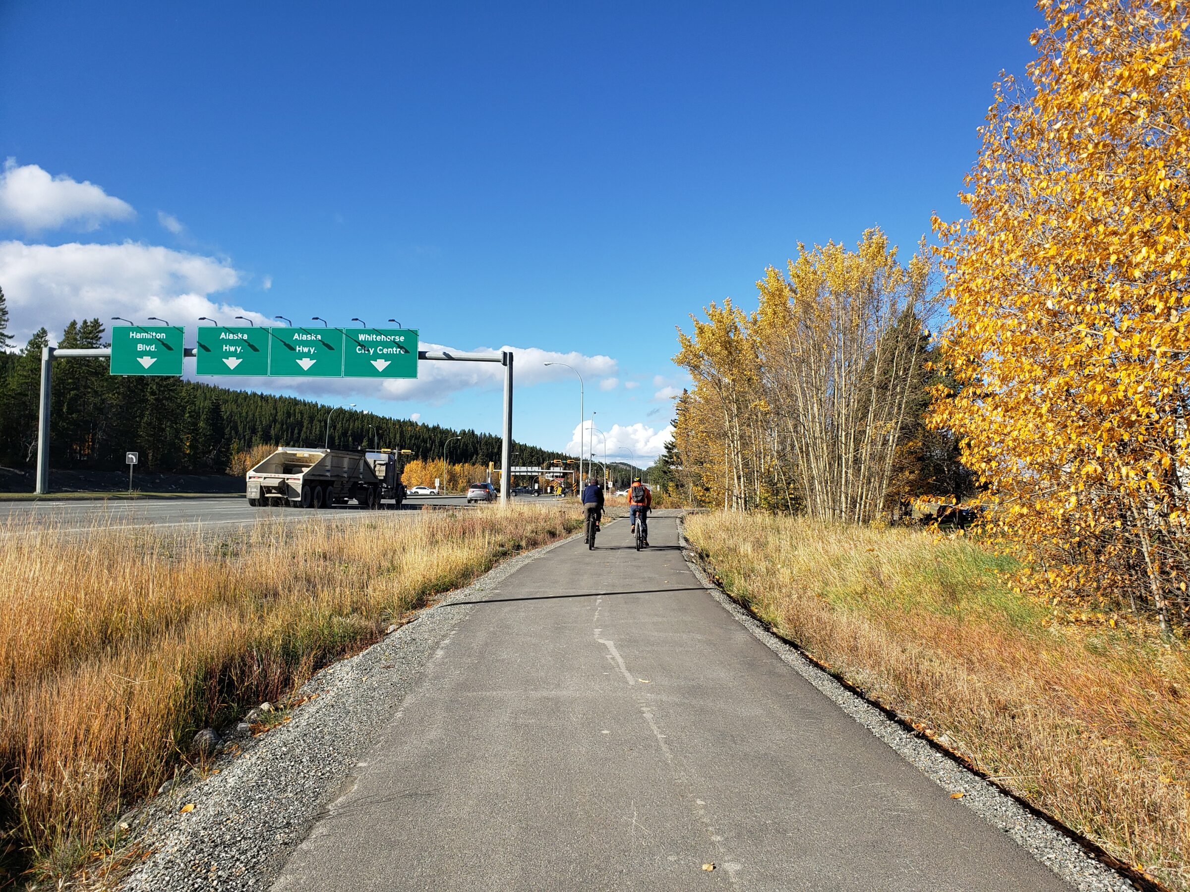 two people riding bikes along a highway