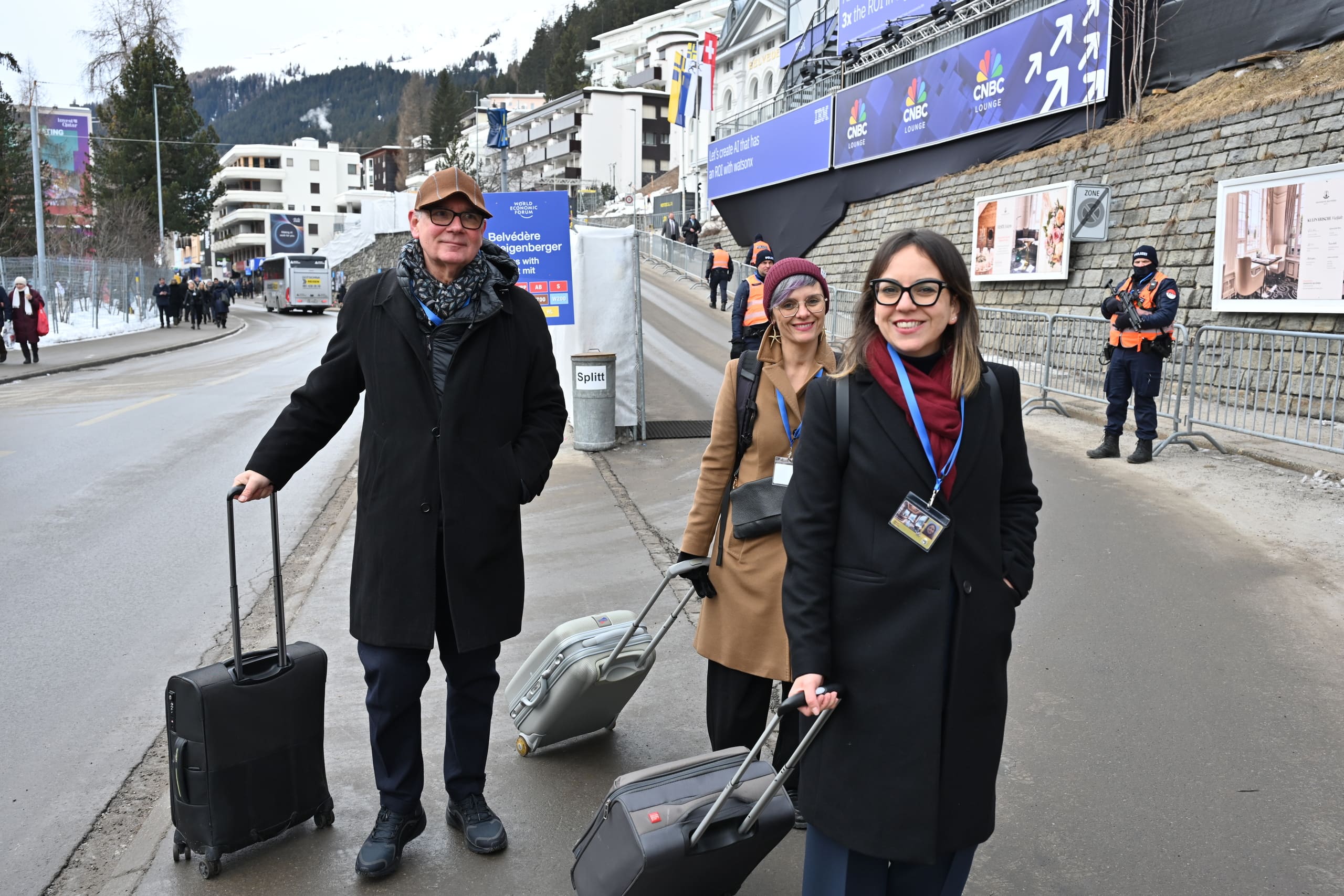 three people standing with luggages 