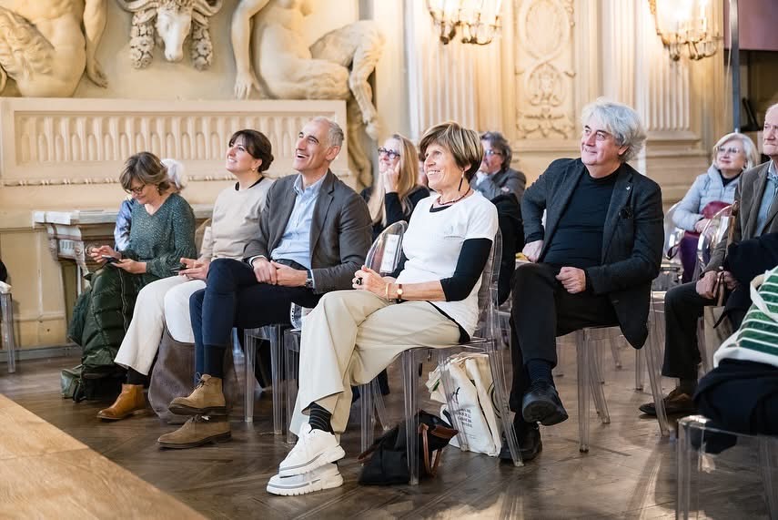 the audience of an event sitting and listening