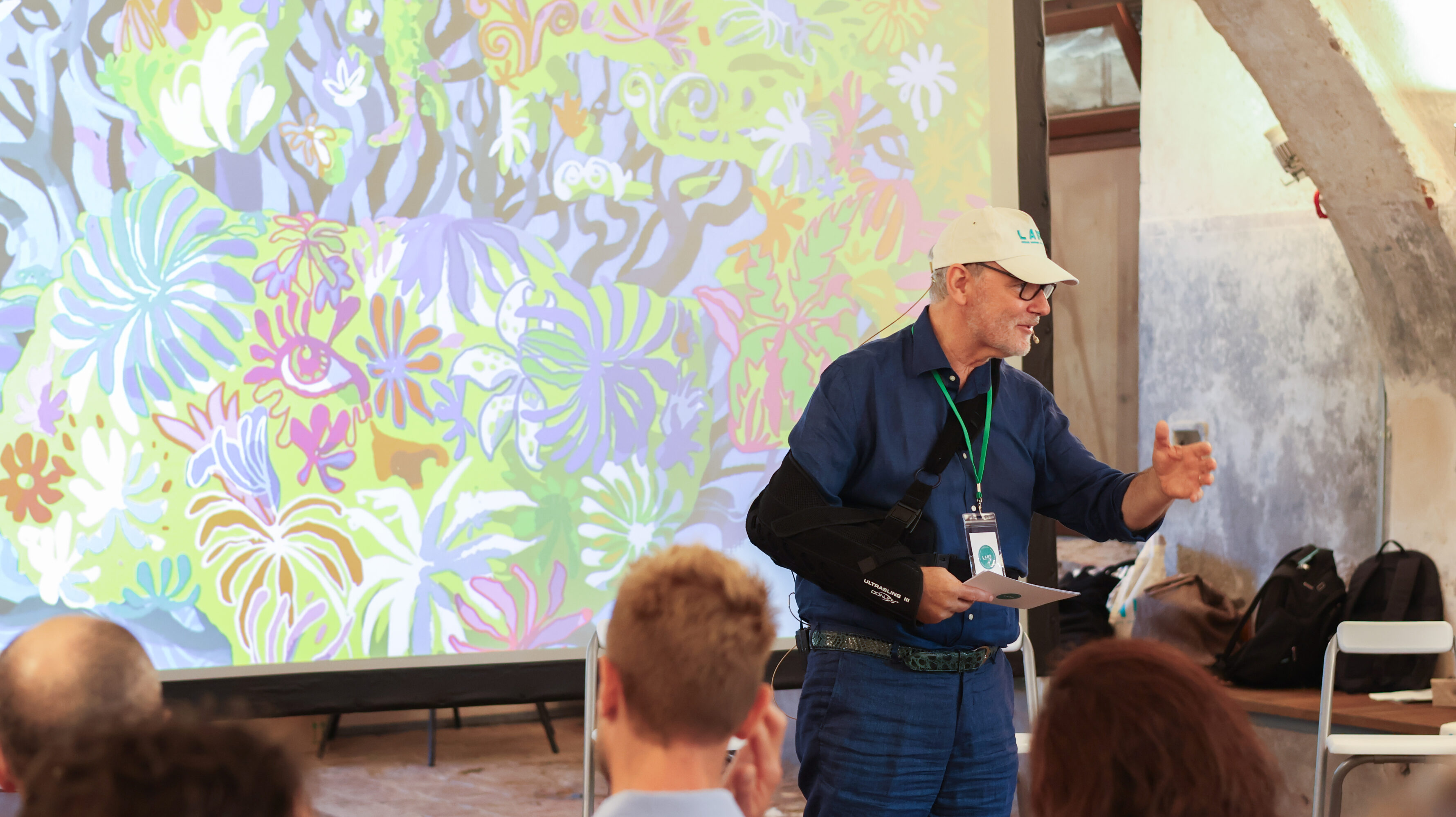 A man speaking at the microfone with a screenplay behind him